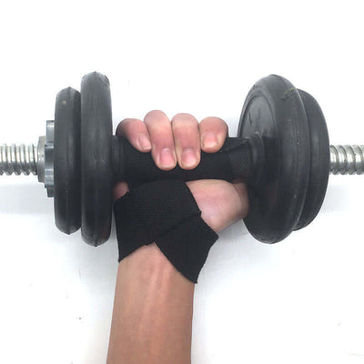 Close-up of a hand gripping a dumbbell with black gym lifting straps for weight training and support.